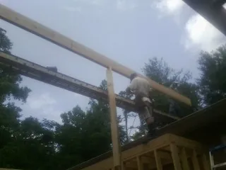 Carpenter setting a ridge beam over a new addition frame — Ice Dam Removal by Roofing Brothers in Ravenel