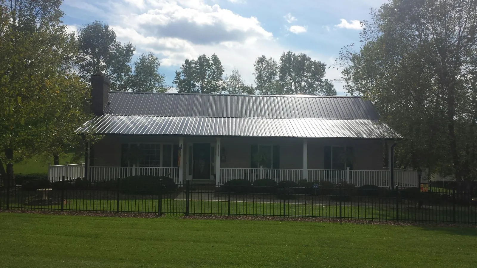 Gray metal roof on a brick ranch with a full width front porch — Gutter Guard Installation work by our crew in Ravenel